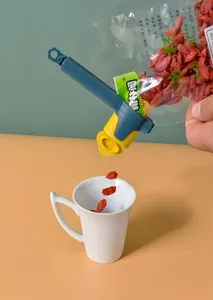 Detail view of a plastic food sealing clip with a spout pouring dried goji berries into a cup.