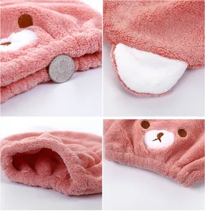 Macro view showing the plush texture and embroidery details of the pink bear hair drying cap.