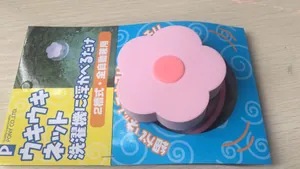 Vue détaillée d'un filtre à peluches flottant rose en forme de fleur avec emballage