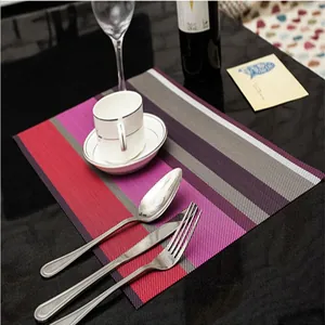 Primo piano di tovaglietta in PVC a righe resistente al calore con posate e tazza