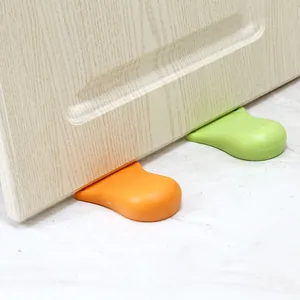Twee kleurrijke voetvormige deurstoppers voor babyveiligheid en botsbescherming.