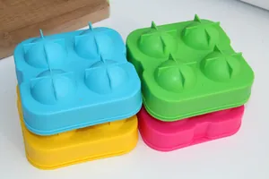 Dettaglio di quattro stampi colorati in silicone per sfere di ghiaccio a 4 fori.