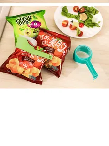 Reusable green food sealing clips with spouts shown attached to snack bags for storage