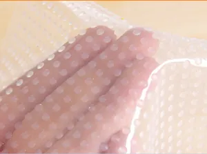 Close-up of transparent food-grade silicone wrap with textured anti-slip grip dots