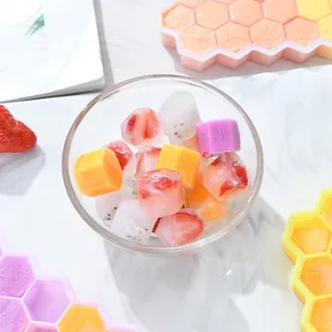 Close-up detail of colorful hexagonal ice cubes with fresh fruit pieces in a glass bowl