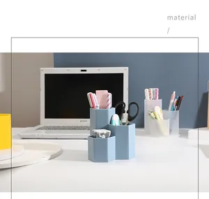 Hexagonal three-slot desk organizer holding pens and scissors in a study setting
