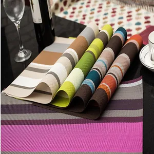 Primo piano di tovagliette intrecciate in PVC con vari motivi a righe per tavolo da pranzo