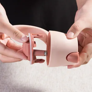 Close-up detail of a pink glass oil dispenser lid assembly with a detachable part