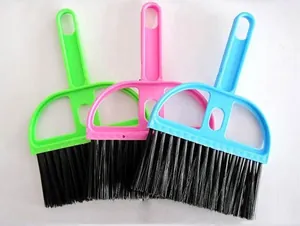 Close-up detail of three mini desktop cleaning brushes in vibrant green, pink, and blue colors.