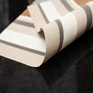 Primo piano del set da tavola in PVC intrecciato con eleganti strisce beige e bianche