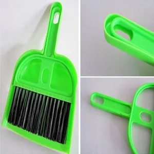 Close-up detail of mini desktop cleaning brush and dustpan set in bright green plastic