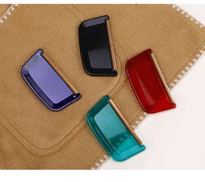 Detailed view of four colorful manual lint removers placed on a tan wool fabric background