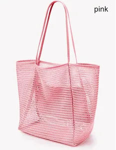 Détail d'un grand sac de plage en filet rose pour la natation et le rangement d'été