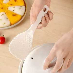 White non-stick rice spoon with textured head and hanging hole for kitchen use