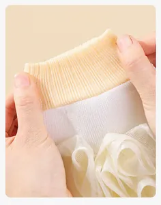 Close-up of the elastic ribbed cuff and soft mesh texture of the exfoliating bath glove.