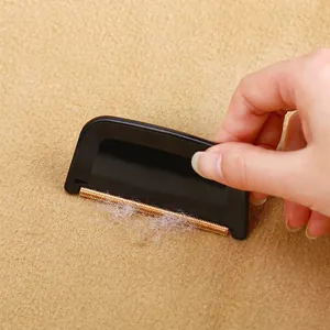Manual portable lint remover for cashmere and wool coats shown in use on fabric