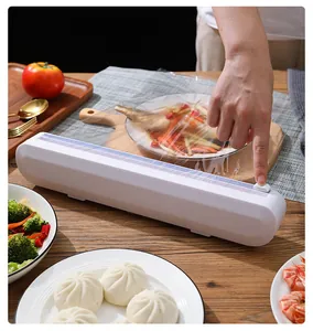 Close-up view of a manual sliding cutter on a white plastic cling film dispenser for kitchen