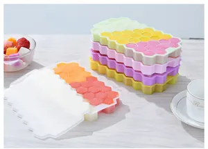 Stack of colorful honeycomb silicone ice cube trays with lids in a kitchen setting