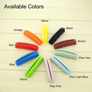 Various bright colors of ergonomic silicone shopping bag handle grips on wood backdrop