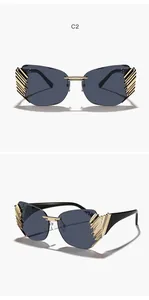 Close-up of rimless sunglasses with gold textured metal accents and dark tinted lenses