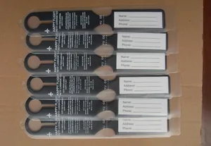 Multiple black long luggage tags with airplane icon and transparent contact label sleeves