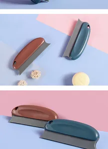 Close-up detail of dual-color pet hair removal brush with serrated edge for grooming.