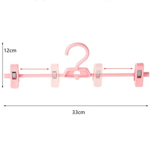 Adjustable pink plastic pants hanger with anti-slip clips, 33cm width dimension guide detail