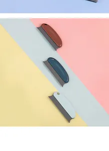 Portable pet hair removal brushes in three colors displayed on a vibrant tricolor background