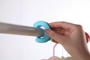 Gros plan d'un clip de tringle à vêtements coupe-vent turquoise fixé sur un étendoir.
