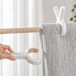 Set of large windproof plastic blanket clips for heavy quilts on wooden laundry rod