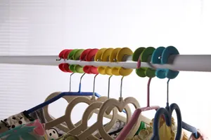 Gros plan de clips en silicone colorés sur une tringle empêchant le glissement