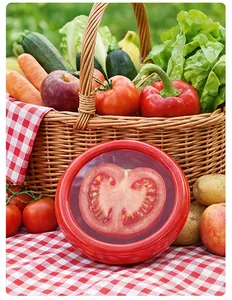 Detail showing red food-grade silicone stretch lid sealing a sliced tomato for freshness.