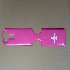 Detailed view of pink silicone luggage tag featuring embossed Happy Flight text and airplane icon