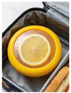 Detail shot showing a yellow round lemon food preservation box inside a lunch bag