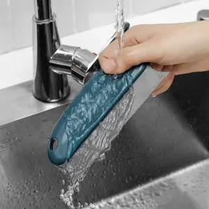 Double-sided pet hair removal brush being rinsed under tap water for easy cleaning