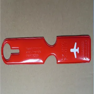 Detail view of a red long luggage tag featuring an airplane icon and travel safety text.