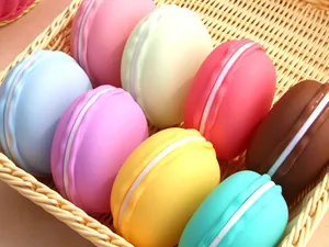 Assorted colorful macaron-shaped portable jewelry storage boxes displayed in a woven basket