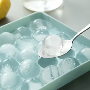 Spherical light blue ice cube tray producing clear round ice balls shown with spoon