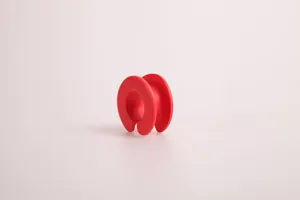 Détail d'un anneau antidérapant en silicone rouge pour fixer les cintres sur la barre