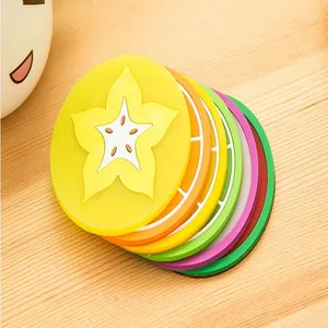 Dettaglio macro di sottobicchieri colorati in silicone a forma di frutta su un tavolo
