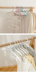 Close-up of extendable children's hangers stacked on a wooden rack