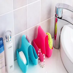 Macro detail view of saddle-style sink sponge holders in blue and pink silicone