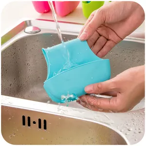 Flexible blue silicone sink caddy being rinsed in a stainless steel kitchen sink