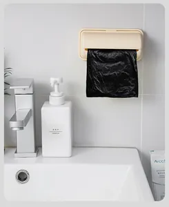 Distributeur de sacs poubelle crème mural installé sur un mur de salle de bain propre