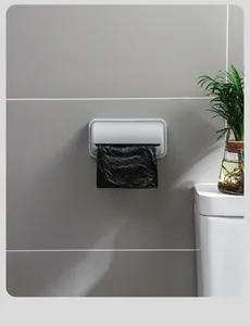 Distributeur mural minimaliste de sacs poubelle installé sur un mur de salle de bain gris