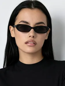 Primo piano di una modella che indossa occhiali da sole ovali neri retrò di tendenza