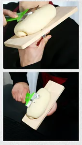 Detailed view of chef using a wooden board and green slicer to shave noodles by hand