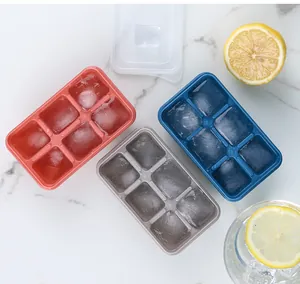 Vista superior de tres cubiteras de 6 cavidades en rosa, azul y gris con limones frescos.