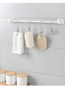 Dettaglio di clip in acciaio inox che tengono accessori da bagno su un'asta bianca