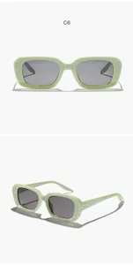 Dettaglio di occhiali da sole rettangolari verde chiaro per bambini con protezione UV.